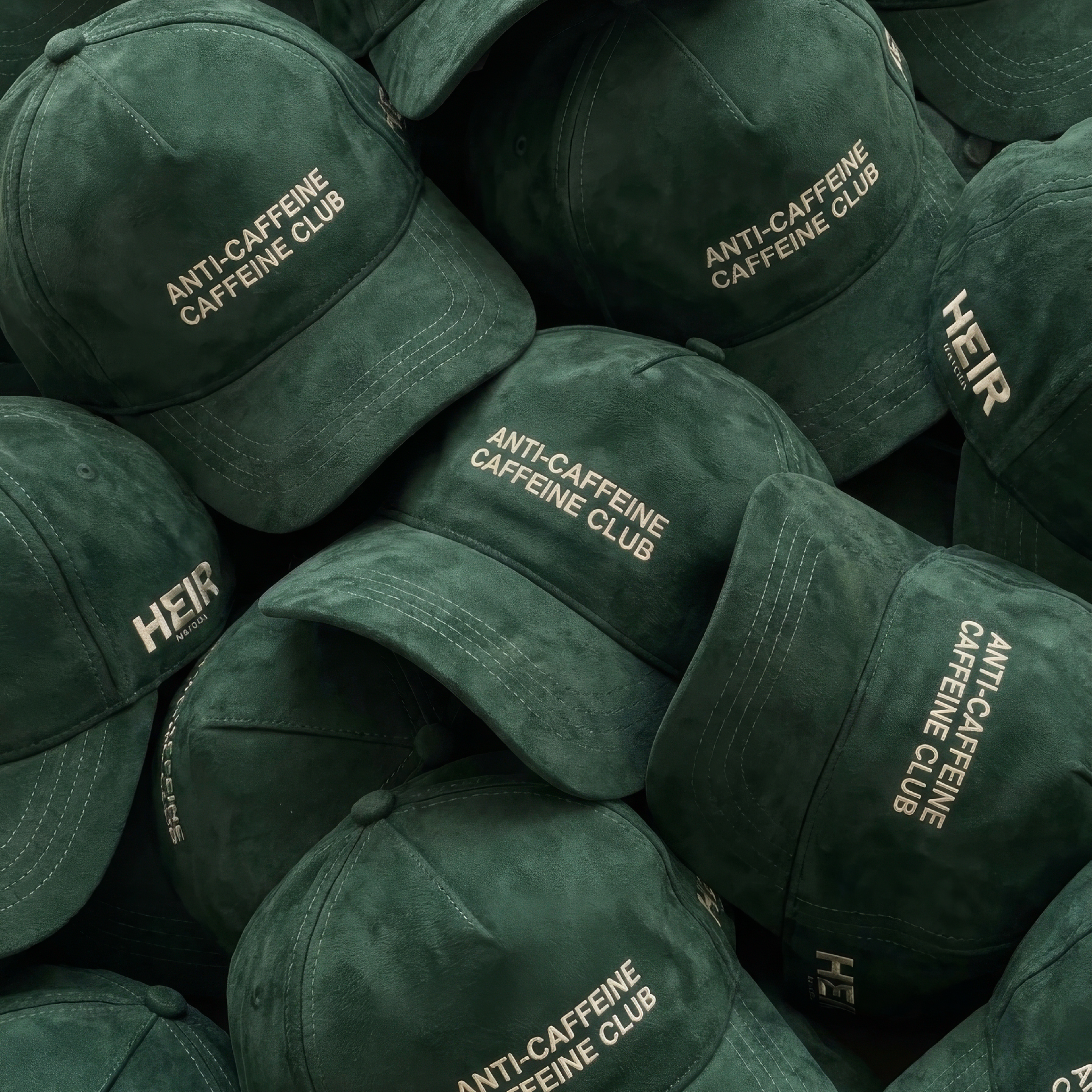 Stack of green caps with 'Anti-Caffeine Caffeine Club' and 'HEIR' text.